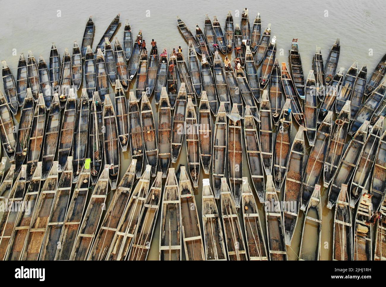 Am Flussufer sind hölzerne Boote aufgestellt, die verschiedene schöne visuelle Muster geschaffen haben. Stockfoto