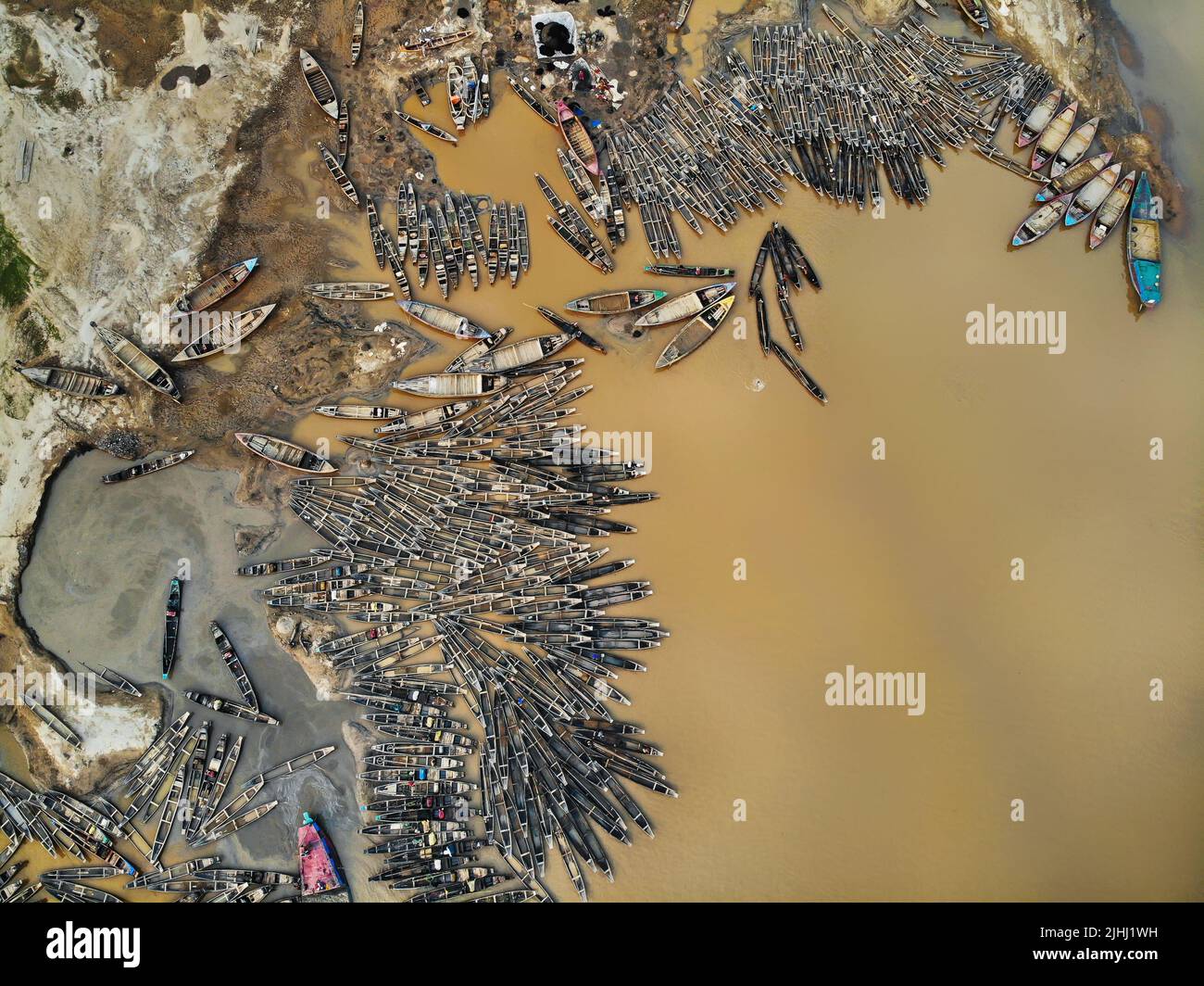 Am Flussufer sind hölzerne Boote aufgestellt, die verschiedene schöne visuelle Muster geschaffen haben. Stockfoto