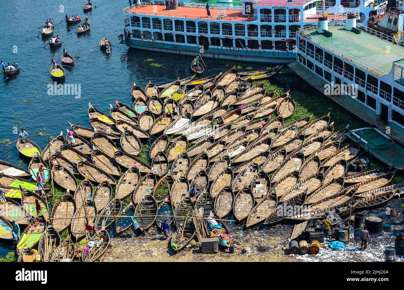 Am Flussufer sind hölzerne Boote aufgestellt, die verschiedene schöne visuelle Muster geschaffen haben. Stockfoto
