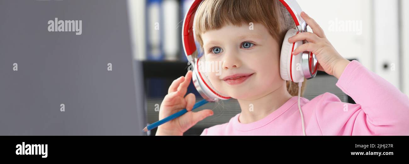Kleines Mädchen beobachten Cartoon auf Laptop, lächelndes Kind tragen Headset, Spaß Zeitvertreib für Kind Stockfoto