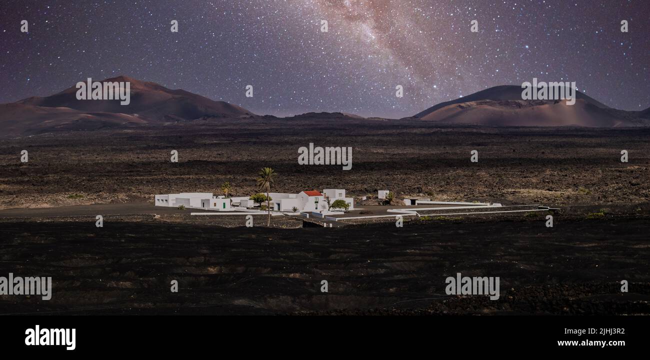 Atemberaubende nächtliche Panoramalandschaft mit Vulkankrater im Timanfaya Nationalpark. Die Milchstraße steht am Nachthimmel über La Gueria auf der Insel Lanzarote Stockfoto