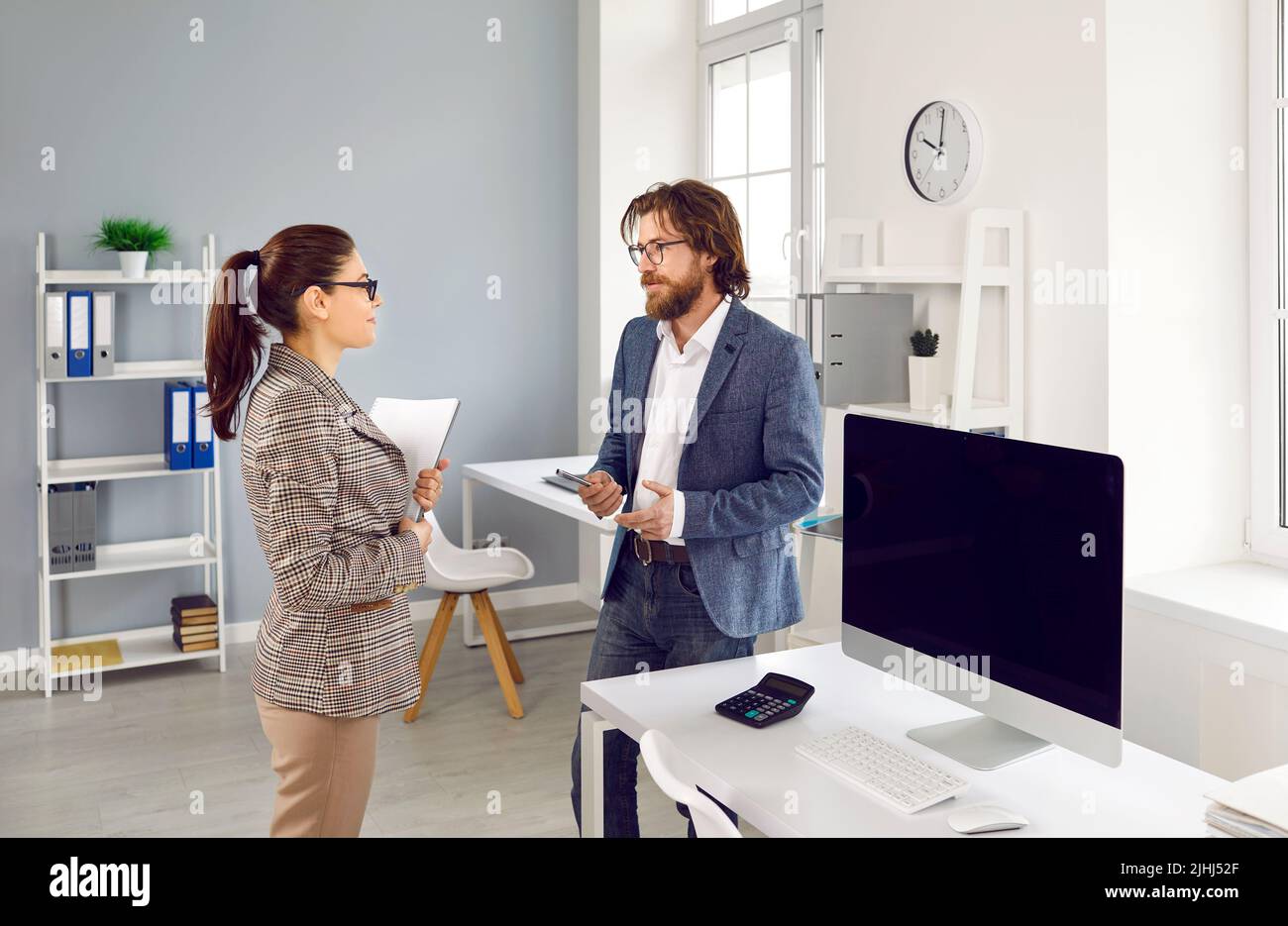 Junger Geschäftsmann im Gespräch mit seinem Bürosekretär, Kollegen oder Finanzbuchhalter Stockfoto