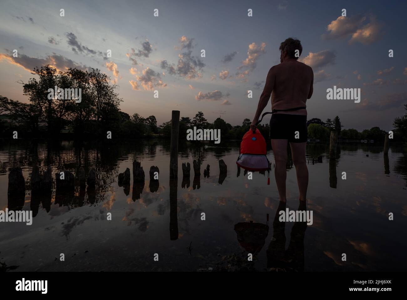 Henley on Thames, Großbritannien. 19.. Juli 2022. An dem möglicherweise heißesten aufgezeichneten Tag Großbritanniens schwimmt ein Freiwasserschwimmer bei Sonnenaufgang in der Themse in der Nähe von Henley auf der Themse. Allan Staley/Alamy Live News Stockfoto