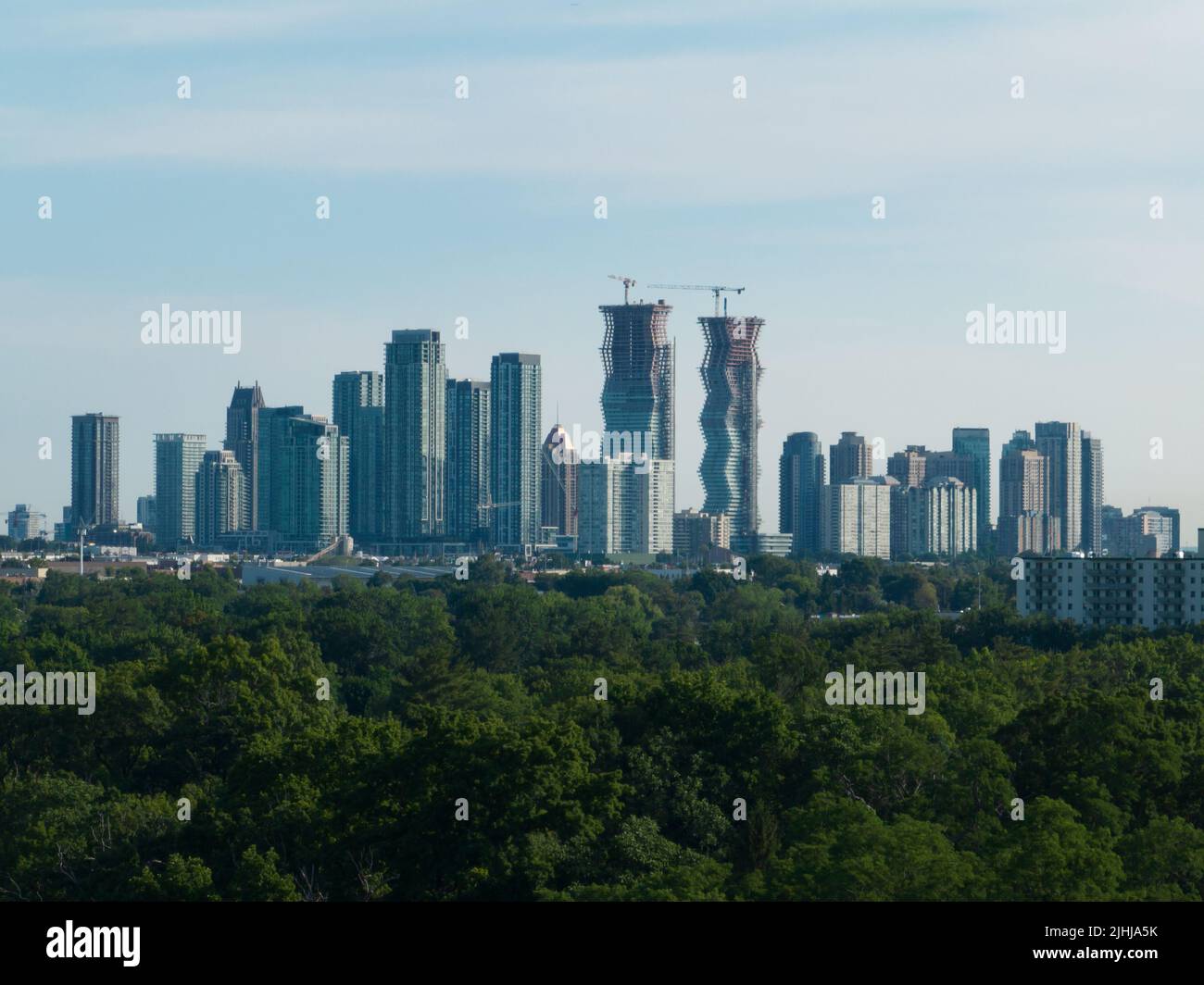 Am Horizont eines sonnigen Tages sieht man eine moderne Skyline mit Stadtbild. Neue Gebäude und Wohnungen sind im Bau. Stockfoto