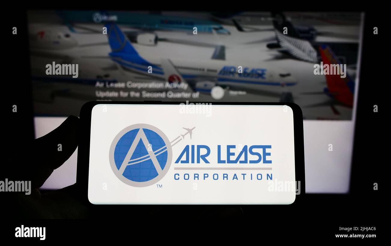 Person, die das Smartphone mit dem Logo der US-Leasinggesellschaft Air Lease Corporation (ALC) auf dem Bildschirm vor der Website hält. Konzentrieren Sie sich auf die Telefonanzeige. Stockfoto