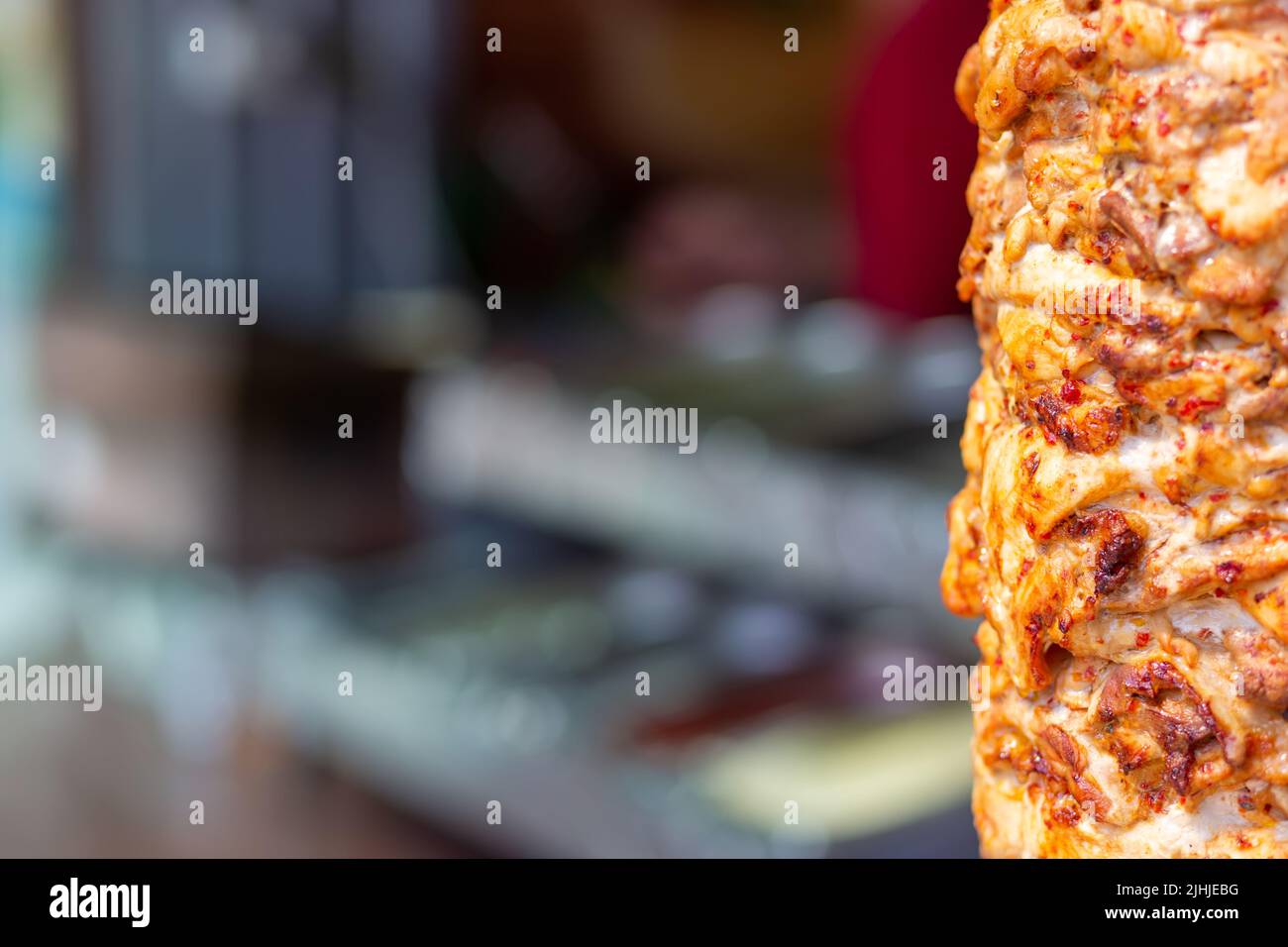 Nahaufnahme der gestapelten Fleischröstung, die für die Zubereitung von traditionellen griechischen Gyros oder türkischen Durum-Dönern verwendet werden kann. Kopierbereich mit verschwommenem Hintergrund Stockfoto