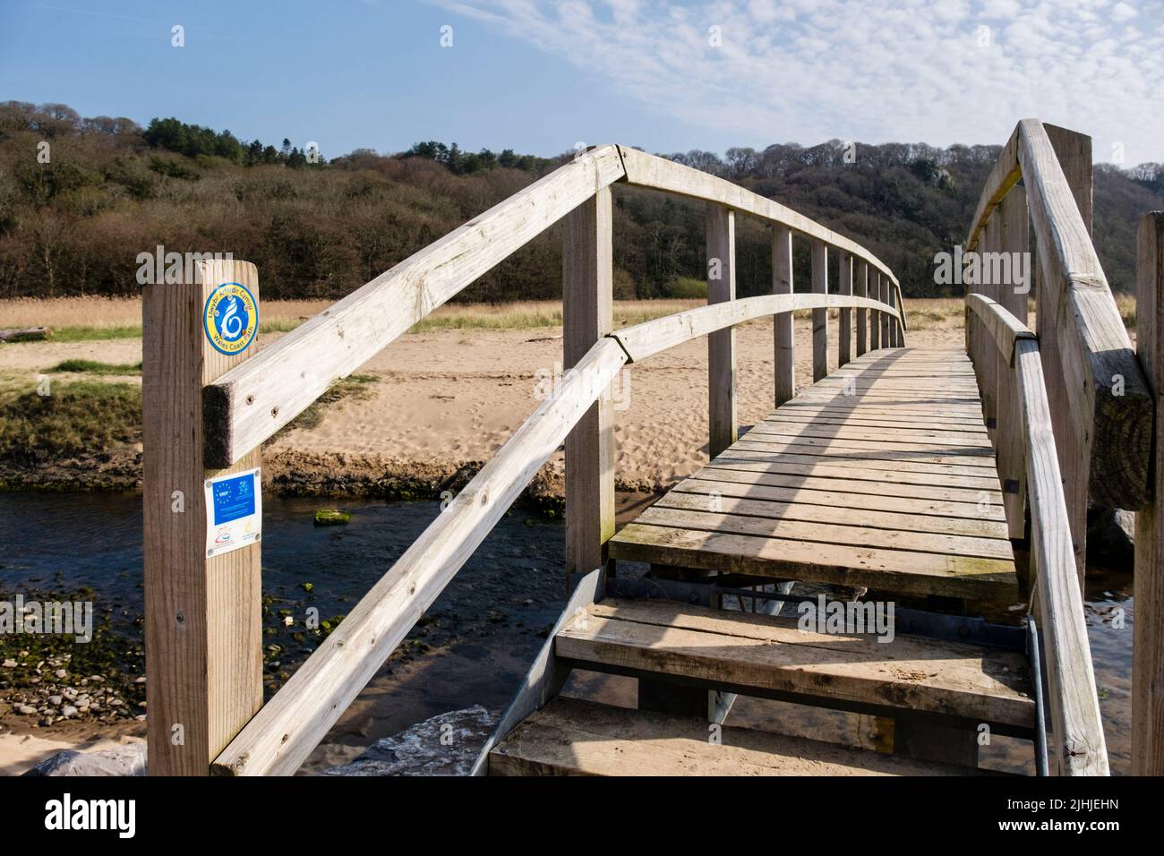 Schild des Wales Coast Path auf der Fußgängerbrücke über den Nicholaston pill Stream im Oxwich National Nature Reserve auf der Gower Peninsula, West Glamorgan, South Wales, Großbritannien Stockfoto
