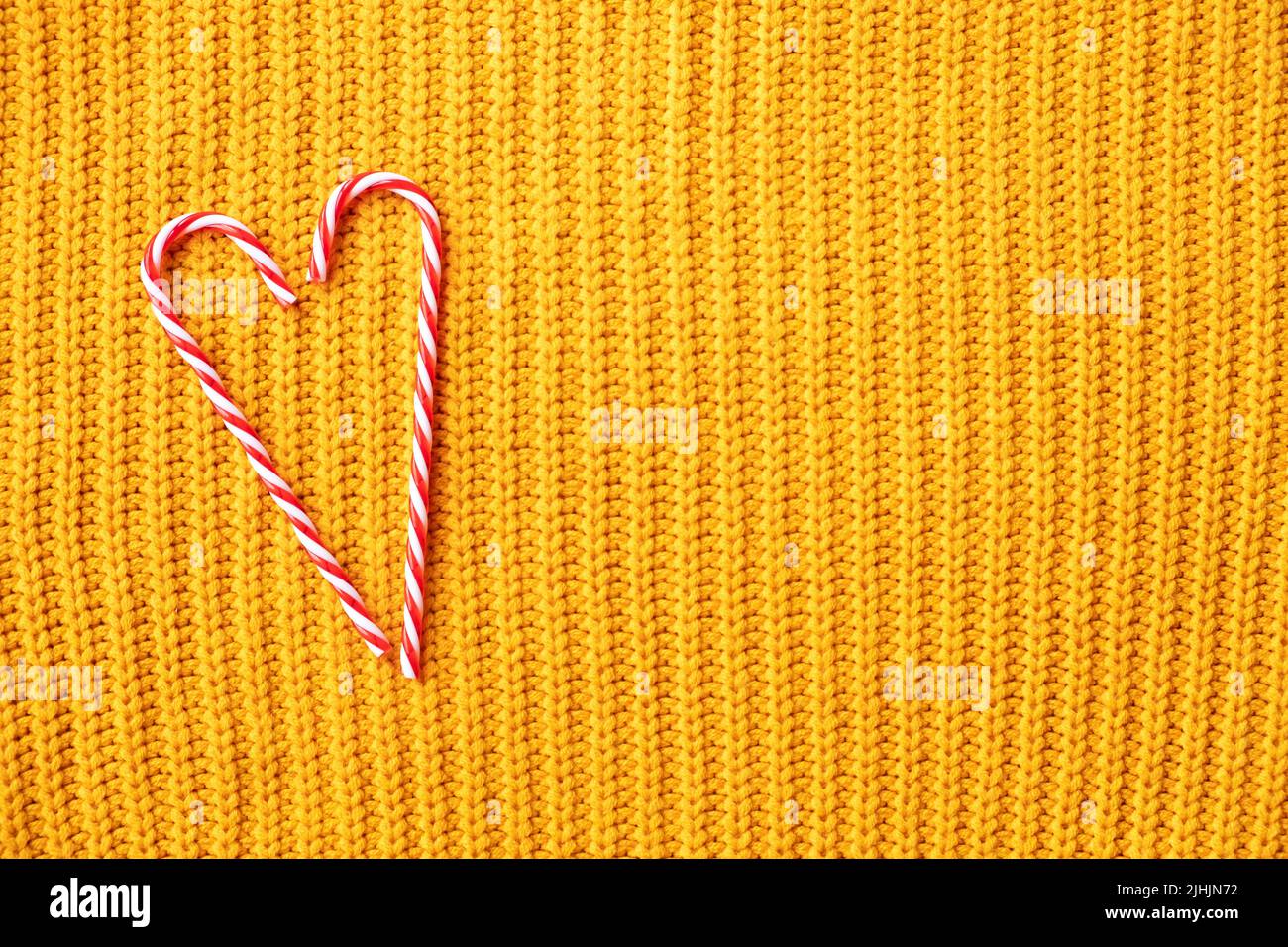 Candy Cane Herz für weihnachten Design auf orange gestrickten Hintergrund mit Copy Space . Weihnachten oder Valentinstag Konzept Stockfoto