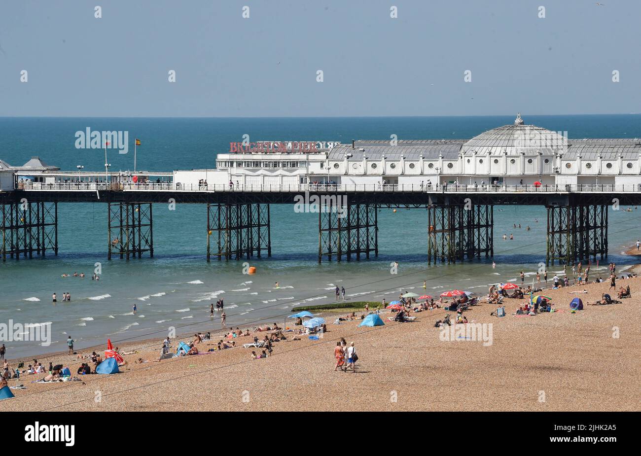 Brighton UK 19. July 2022 - Sonnenanbeter genießen den heißesten Tag des Jahres am Brighton Beach östlich des Brighton Palace Pier, da heute für Teile Großbritanniens Temperaturen von über 40 Grad prognostiziert werden. Eine rote Unwetterwarnung ist noch vorhanden, aber die Bedingungen werden sich in den nächsten Tagen abkühlen : Credit Simon Dack / Alamy Live News Stockfoto