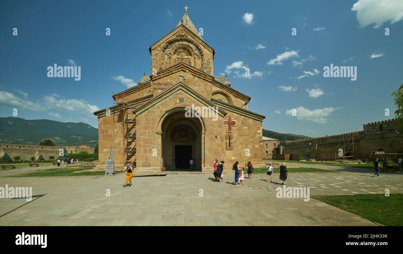 Kathedrale von Svetizchoveli (Kathedrale der Lebendigen Säule) in Mzcheta, Georgien, Außenansicht von Tageslicht mit Besuchern, die die Kathedrale betreten Stockfoto
