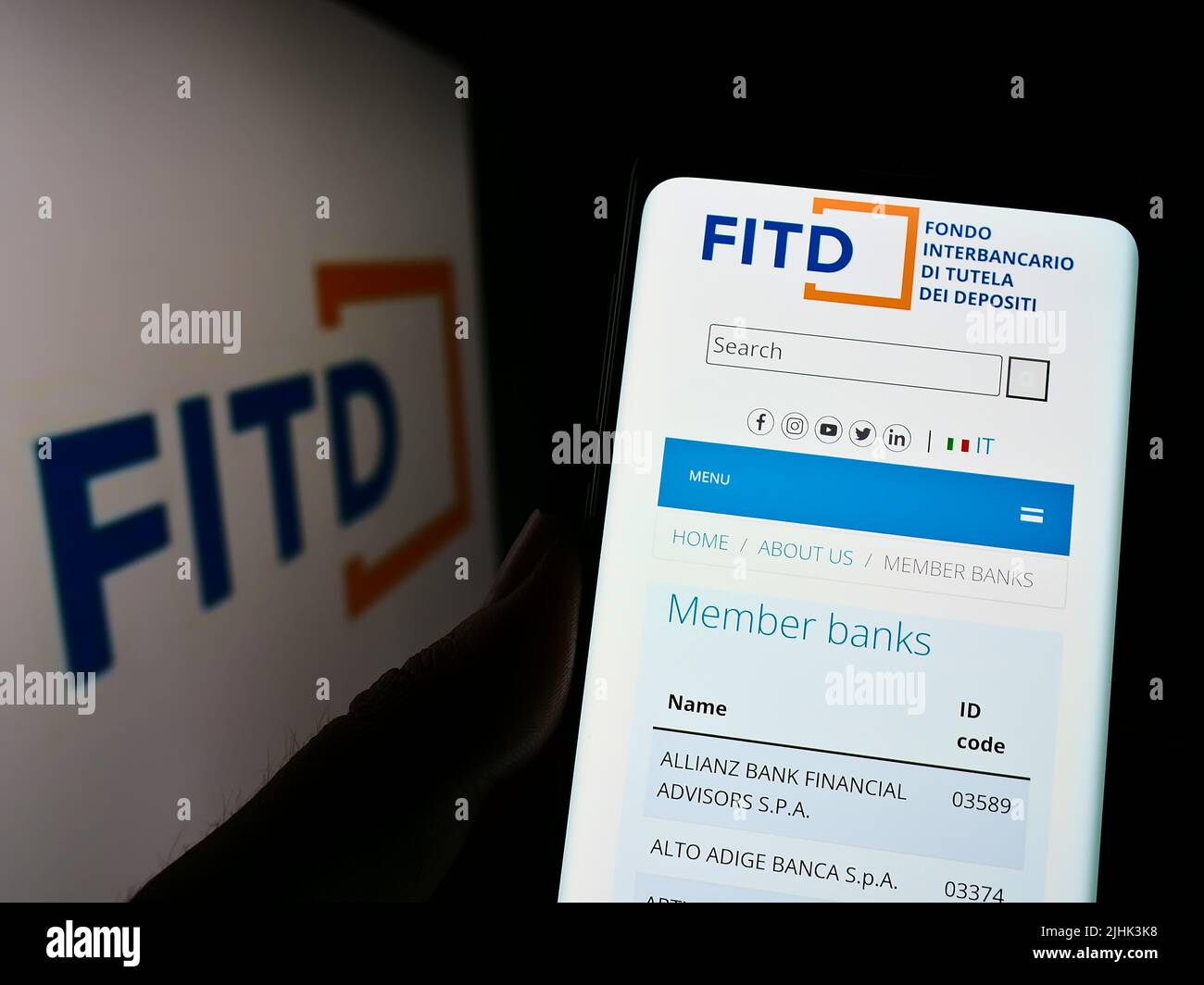 Person mit Mobiltelefon und Webseite von Fondo Interbancario di Tutela dei Depositi (FITD) auf dem Bildschirm mit Logo. Konzentrieren Sie sich auf die Mitte des Telefondisplays. Stockfoto