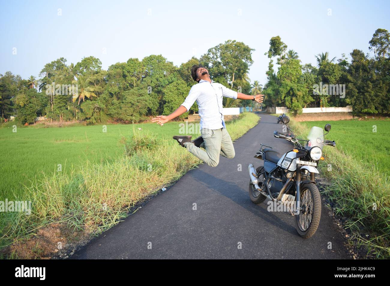 Ein Mann posiert für Foto mit Motorrad in der Nähe von Reisfeld Stockfoto
