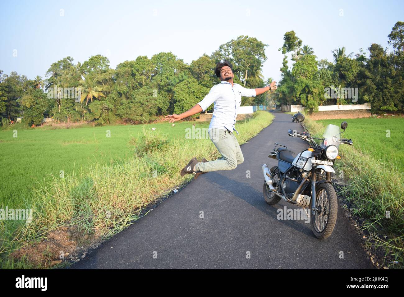 Ein Mann posiert für Foto mit Motorrad in der Nähe von Reisfeld Stockfoto