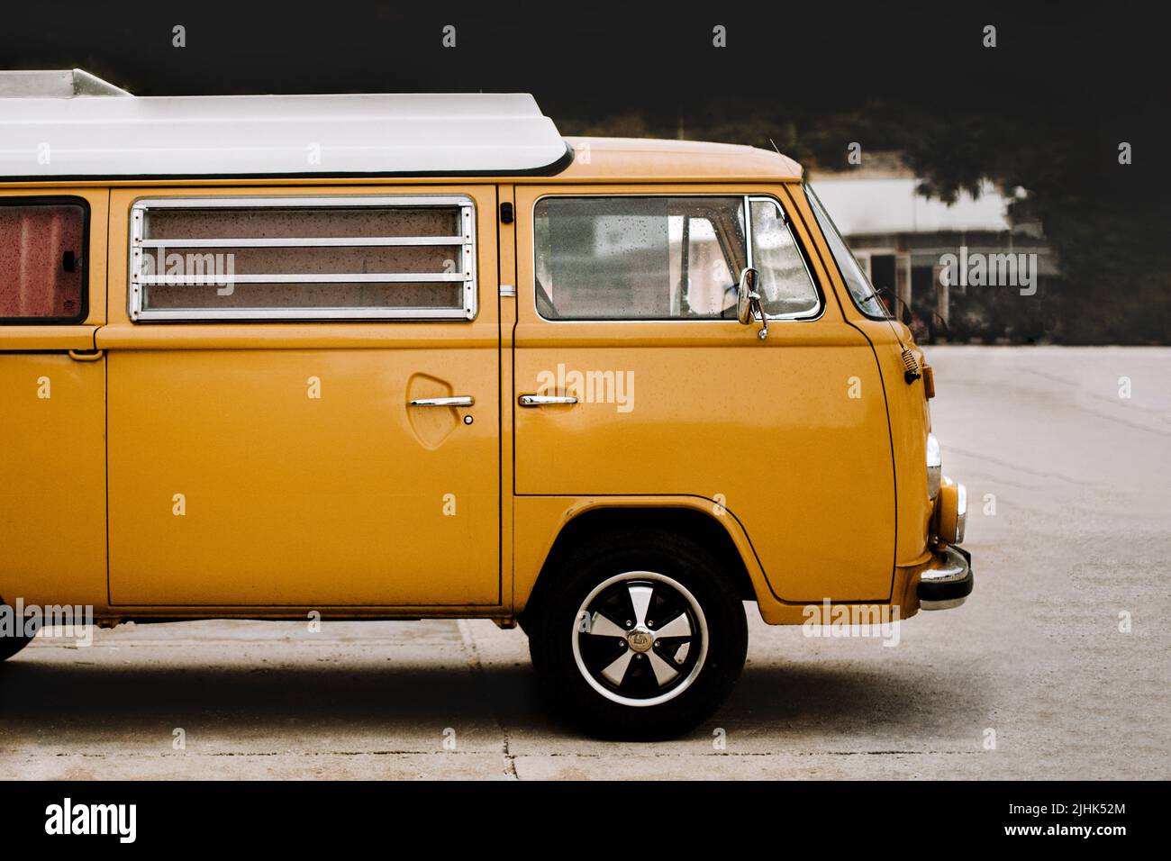 Orange Retro, Vintage Wohnmobil von der Seite geschossen. Lieferwagen mit glänzenden Chromrädern und Chrom-Fenstergittern. Bereit für alte Schule Reisekonzept. Stockfoto