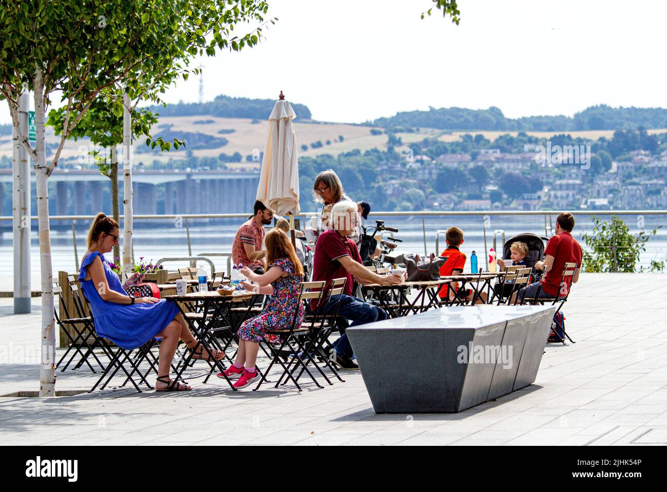 Dundee, Tayside, Schottland, Großbritannien. 19.. Juli 2022. Wetter in Großbritannien: Die Temperaturen im Nordosten Schottlands haben 29 Grad Celsius erreicht, was zu orangen Warnungen bei extremen Hochtemperatur-Temperaturen führte. Trotz der Luftfeuchtigkeit genießen Anwohner und Touristen das wunderschöne Wetter und kaufen Eiskegel, kalte Getränke und Kaffee vor dem V&A Design Museum auf Dundees Waterfront Development Project. Kredit: Dundee Photographics/Alamy Live Nachrichten Stockfoto