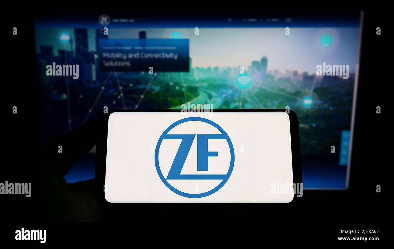 Person, die Smartphone mit Logo des Automobilkonzerns ZF Friedrichshafen AG auf dem Bildschirm vor der Website hält. Konzentrieren Sie sich auf die Telefonanzeige. Stockfoto
