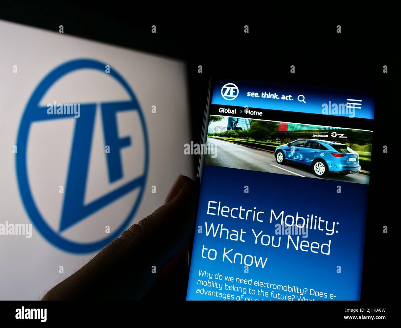 Person, die Mobiltelefon mit Website des Automobilunternehmens ZF Friedrichshafen AG auf dem Bildschirm vor dem Logo hält. Konzentrieren Sie sich auf die Mitte des Telefondisplays. Stockfoto