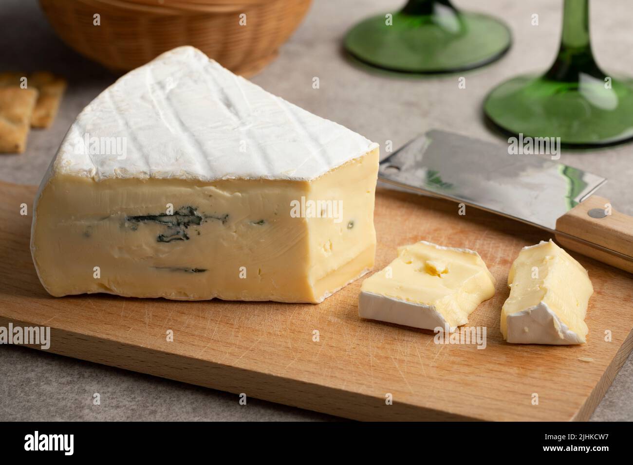 Stück weicher deutscher Cambozola, blauer Brie-Käse auf einem Schneidebrett aus nächster Nähe Stockfoto