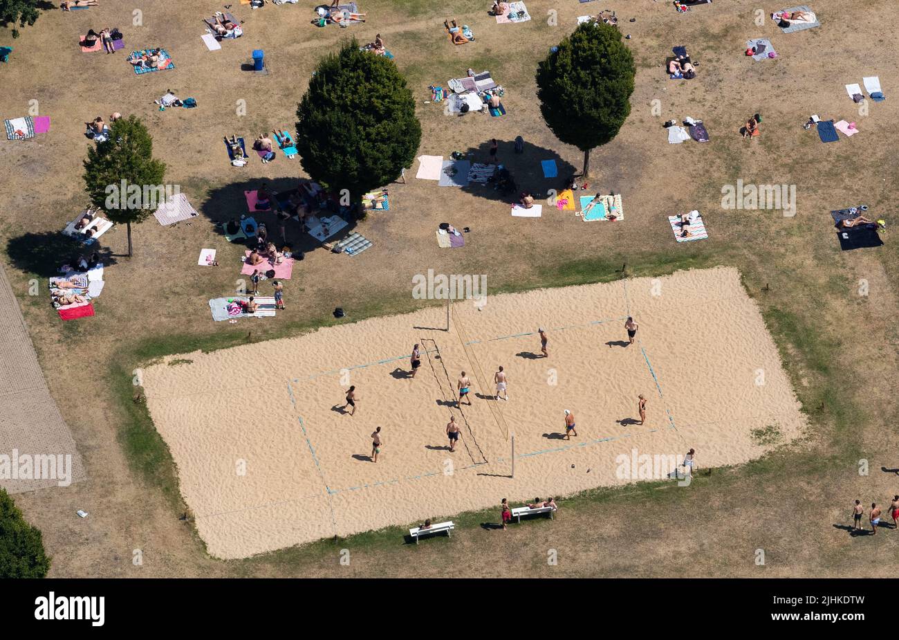 Bielefeld, Deutschland. 19.. Juli 2022. Badegäste spielen Beachvolleyball und liegen mit ihren Handtüchern auf dem Rasen eines Außenpools. Es werden bis zu 40 Grad Celsius erwartet (Luftaufnahme mit einer Drohne). Quelle: Friso Gentsch/dpa/Alamy Live News Stockfoto