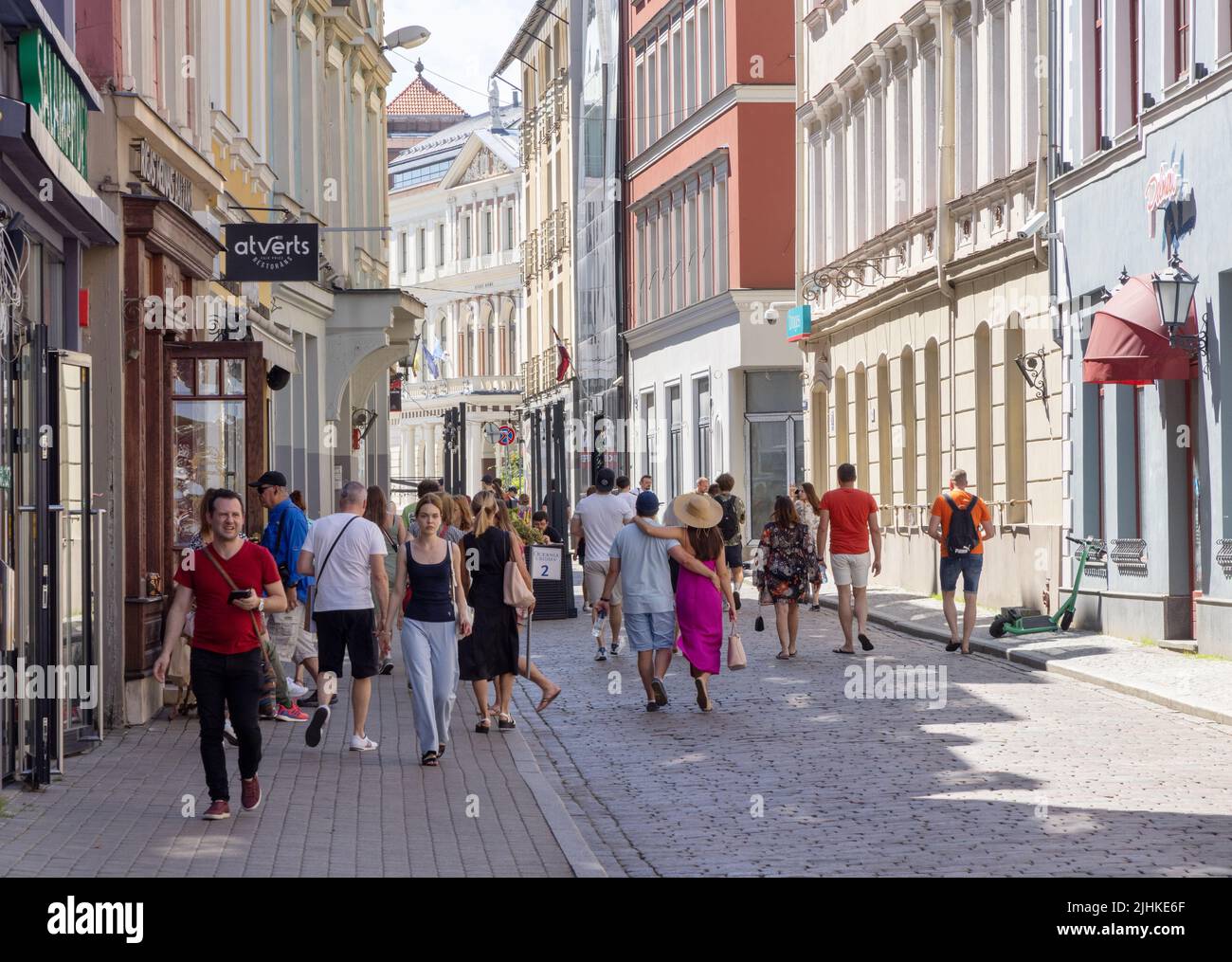 Tagszene der Rigaer Straße; Touristen und Einheimische, die in der Altstadt von Riga in der Sommersonne auf einer gepflasterten Straße spazieren, Riga Lettland Europa Stockfoto