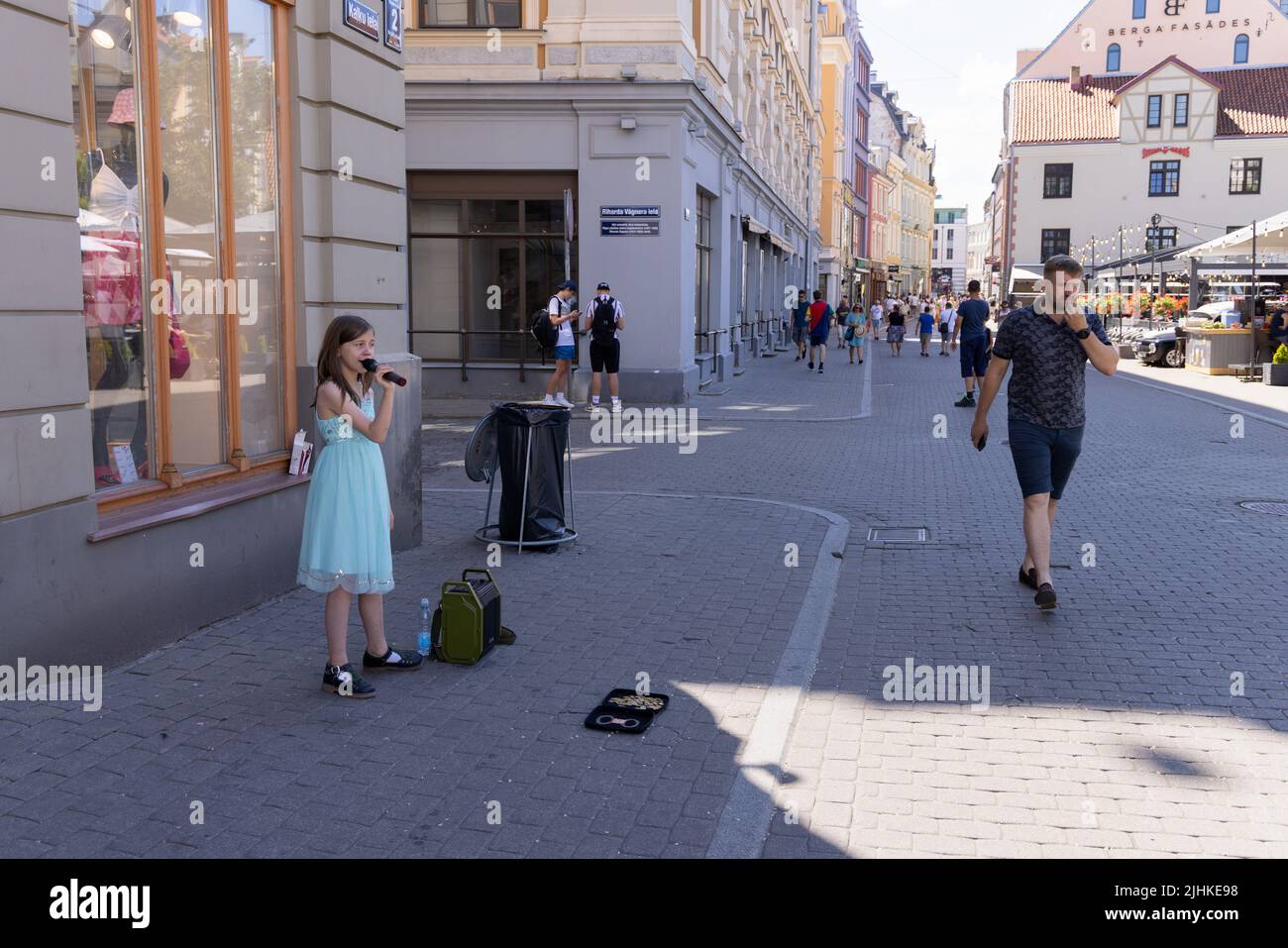 Kinder spielen; Ein Kind Straßenmusiker Riga; ein junges Mädchen im Alter von 10 Jahren singen, um Geld zu sammeln, Riga Altstadt, Riga Lettland Europa Stockfoto