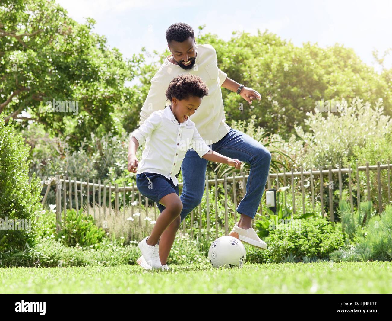 Spielen wie echte Fußballstars. Ein Vater und Sohn spielen gemeinsam im Freien Fußball. Stockfoto