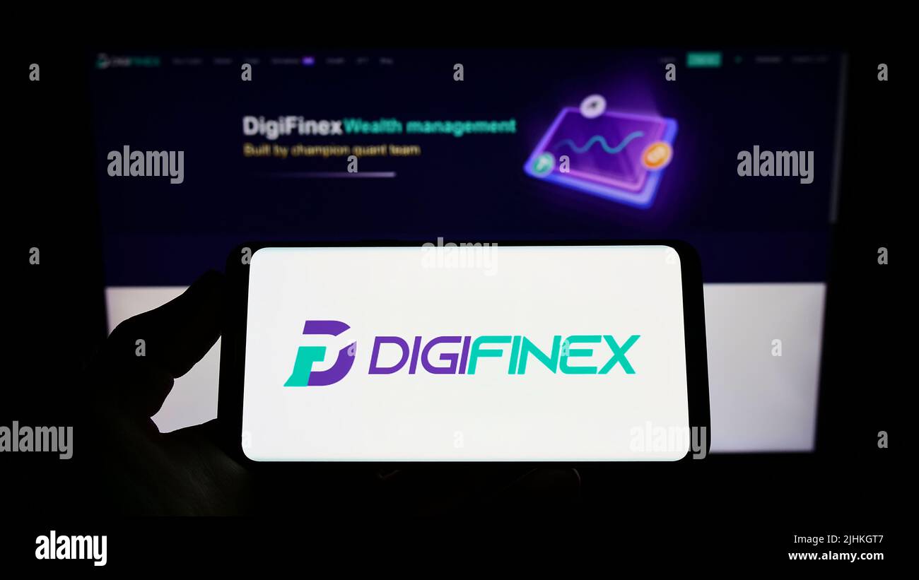 Person, die Smartphone mit dem Logo der Krypto-Exchange-Firma DigiFinex Limited auf dem Bildschirm vor der Website hält. Konzentrieren Sie sich auf die Telefonanzeige. Stockfoto