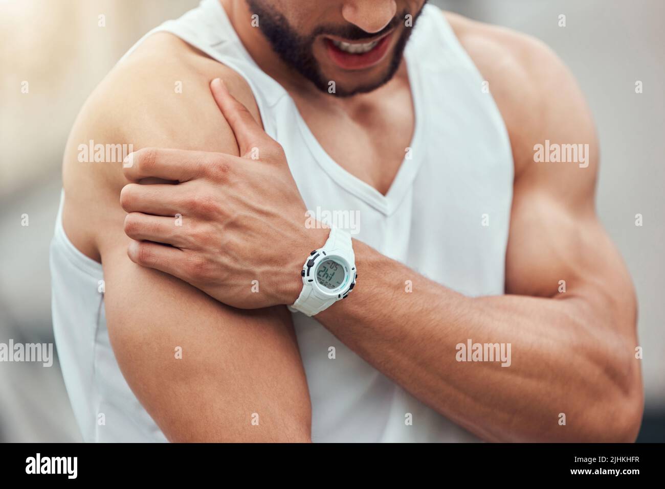 Ein unbekannter gemischter Tennisspieler mit Schulterverletzung im Gerichtsspiel. Hispanic fit professionell in Schmerzen beim Halten und Reiben Arm Stockfoto
