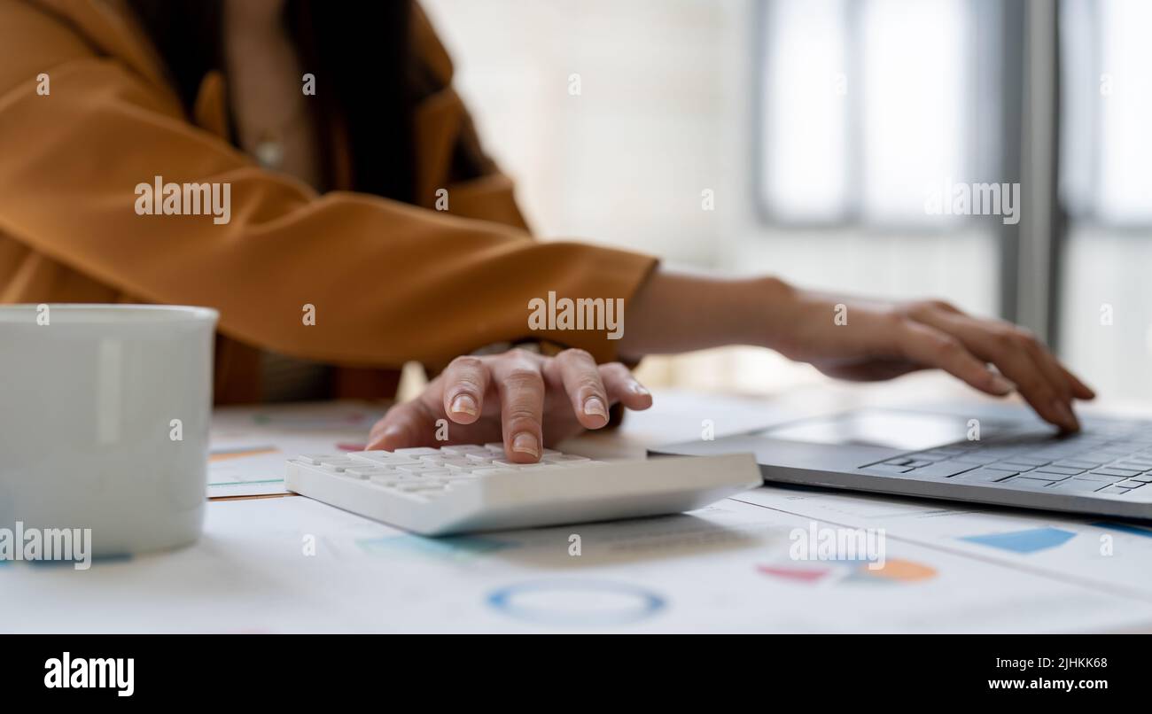 Geschäftsfrau oder Buchhalterin, die finanzielle Investitionen in Kalkulator, berechnen, analysieren Geschäft und Marketing-Wachstum auf Finanzdokumenten-Daten Stockfoto
