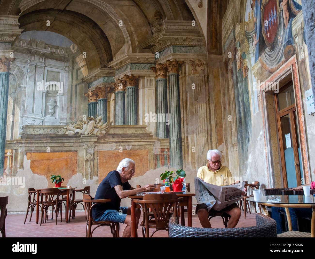 Italienische Herren entspannen sich in Sedile Dominova, einem historischen Gebäude mit Originalfresken, das jetzt als funktionstüchtiger Männerclub dient, in Sorrento, Italien. Stockfoto