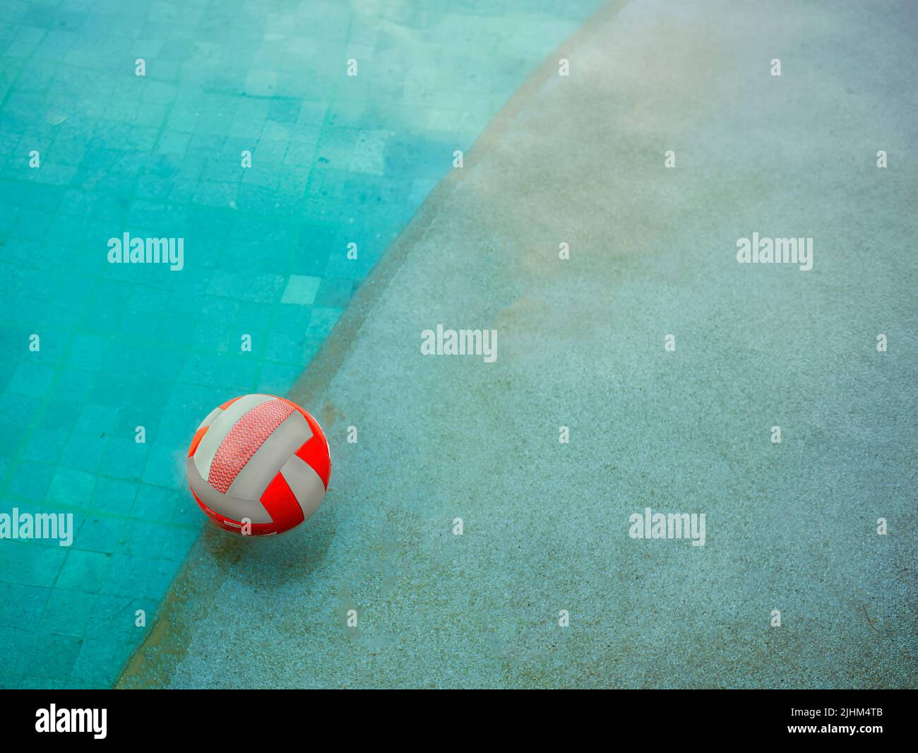 Ein Wasservolleyball, der an einem regnerischen Tag im Schwimmbad auf dem Wasser schwimmt Stockfoto