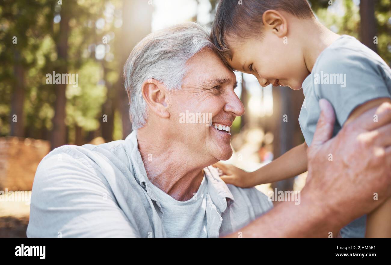 Ich liebe dich, mein Junge. Ein hübscher reifer Mann und sein Großvater teilen sich einen intimen Moment, während sie im Wald zelten. Stockfoto