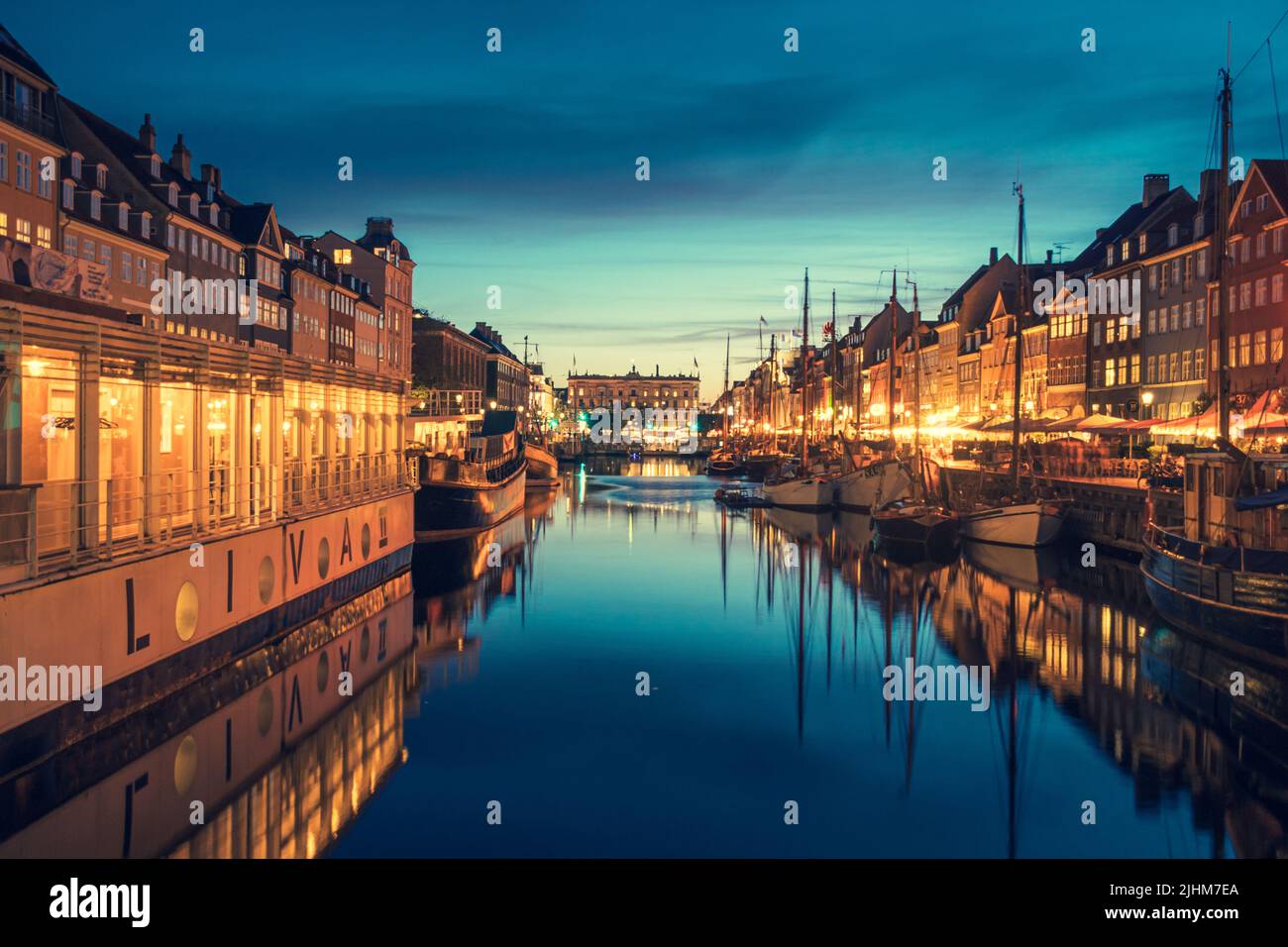 Schöne Aussicht mit farbenfroher Fassade aus traditionellen Häusern und alten Holzschiffen entlang des Nyhavn-Kanals oder des Neuen Hafens, Nachtblick Stockfoto