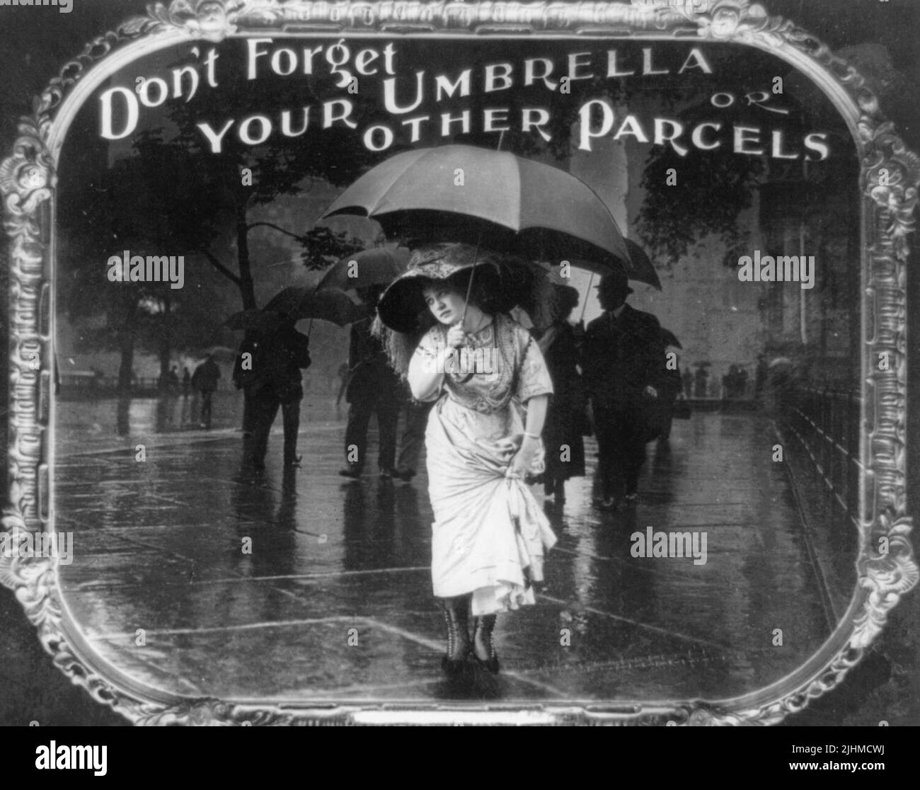 Vergessen Sie nicht Ihren Regenschirm oder andere Pakete – das Foto zeigt eine Frau, die einen Regenschirm hält, während sie eine nasse Straße überquert. Positiver Papierdruck von Laternenfolie, der in Filmtheatern als Ankündigung verwendet wird. Stockfoto