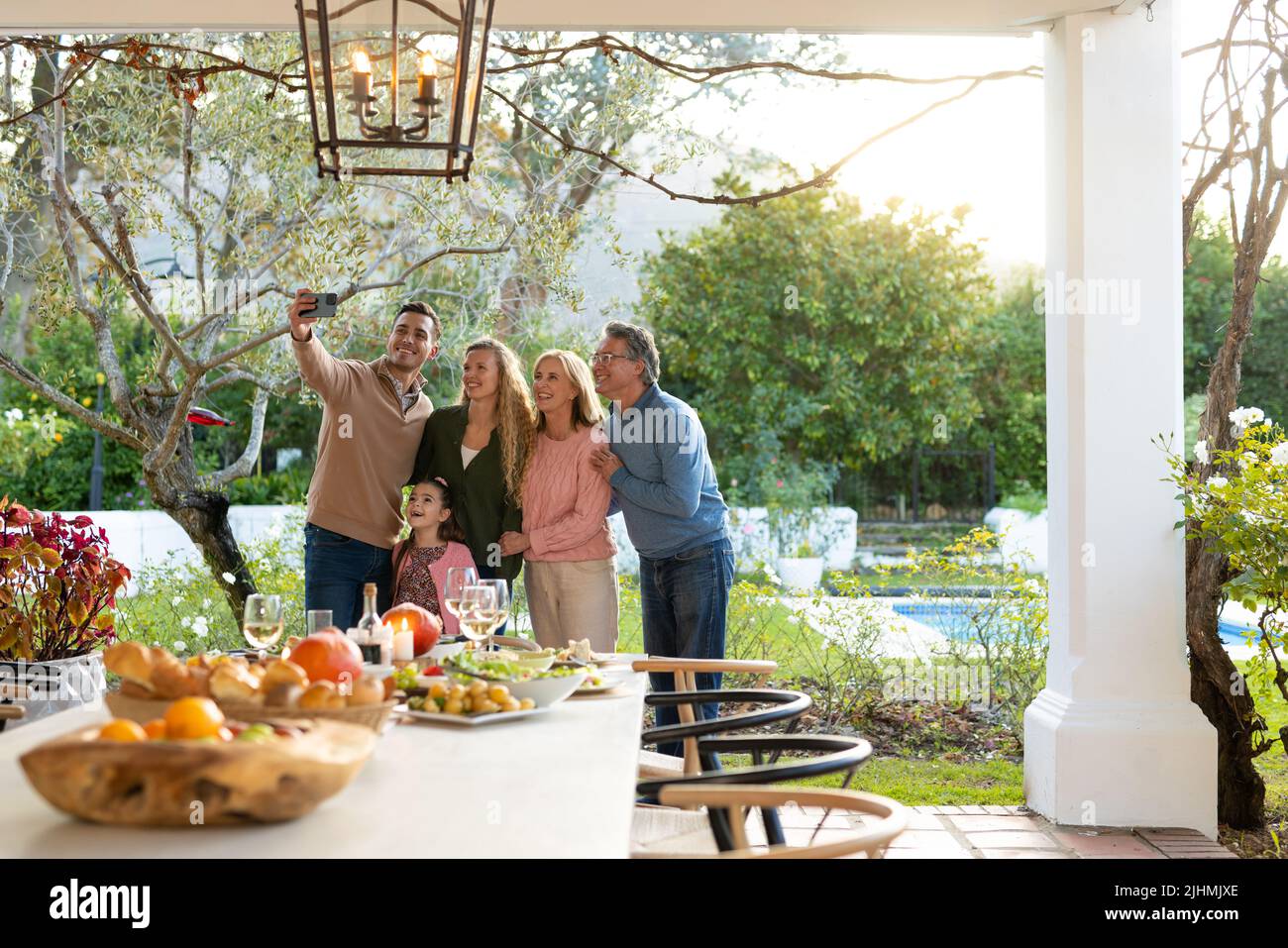 Bild einer glücklichen, mehrgeneration kaukasischen Familie, die nach dem Abendessen auf der Terrasse Selfie macht Stockfoto