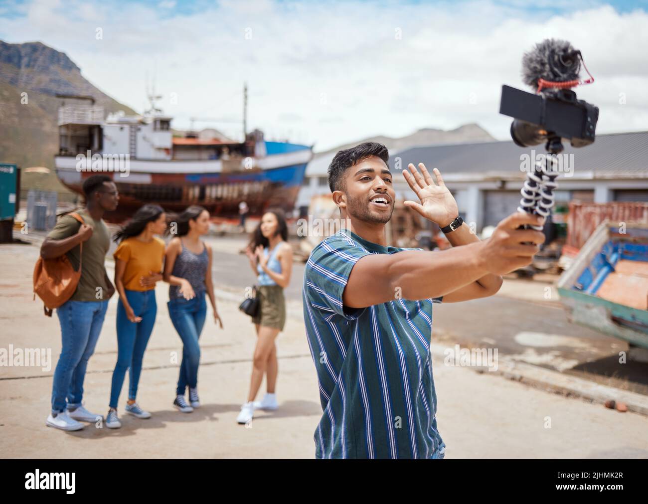 Hey Jungs hängen heute mit meiner Crew zusammen. Ein junger Mann, der eine Digitalkamera auf einem Stativ verwendet, während er mit seinen Freunden draußen rumhängt. Stockfoto