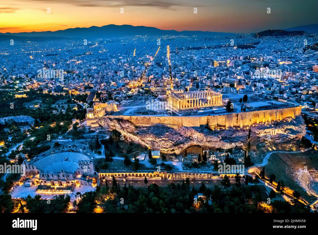 Luftaufnahme der Akropolis von Athen (Griechenland) bei Sonnenuntergang. Sie können auch einen großen Teil der Stadt im Hintergrund sehen und das Herodeum darunter. Stockfoto