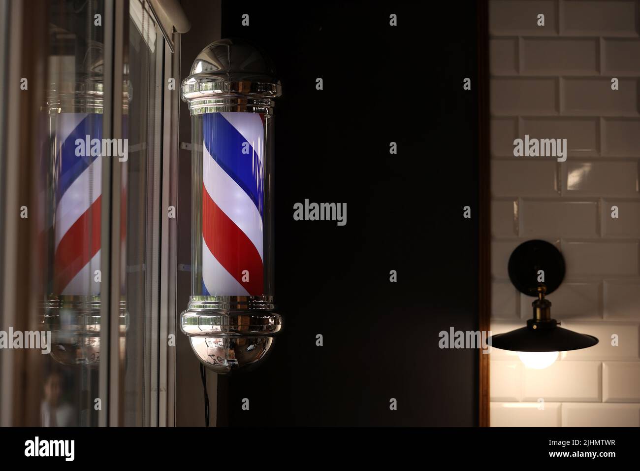 Friseursalon Vintage Pole. Copyspace Barbershop. Friseurladen Stange in rot weiß und blau mit Glühbirne auf der Oberseite Stockfoto