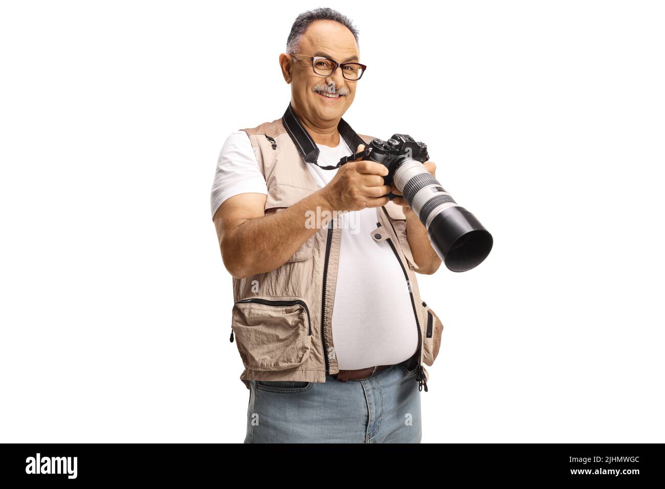 Reifer männlicher Fotojournalist, der eine professionelle Kamera hält und die Kamera auf weißem Hintergrund isoliert anlächelt Stockfoto