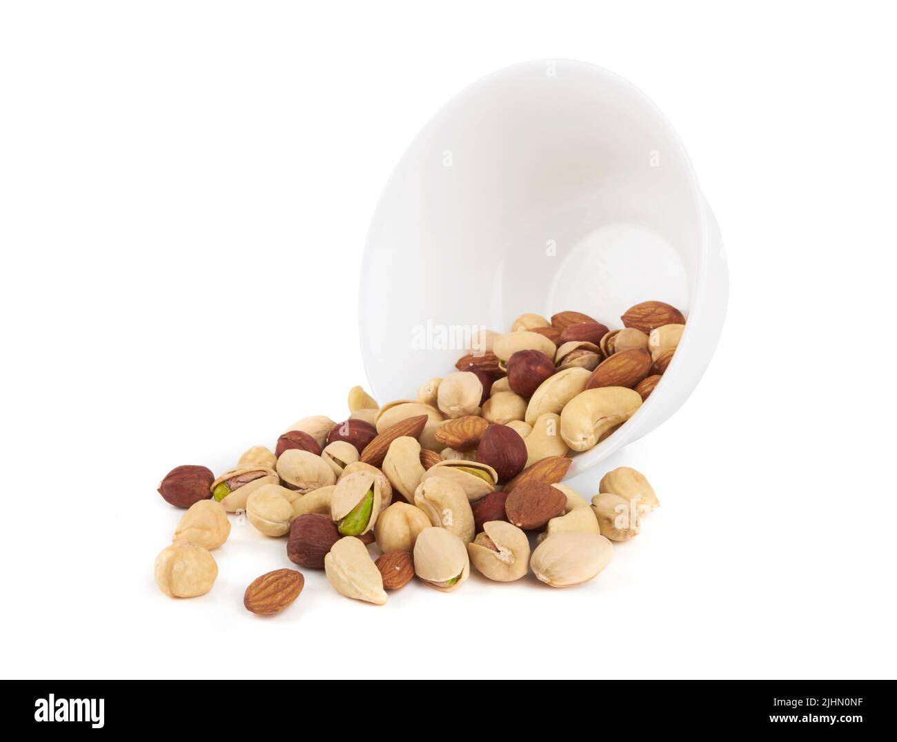 Haufen von gemischten Nüssen in Schüssel isoliert auf weißem Hintergrund Stockfoto