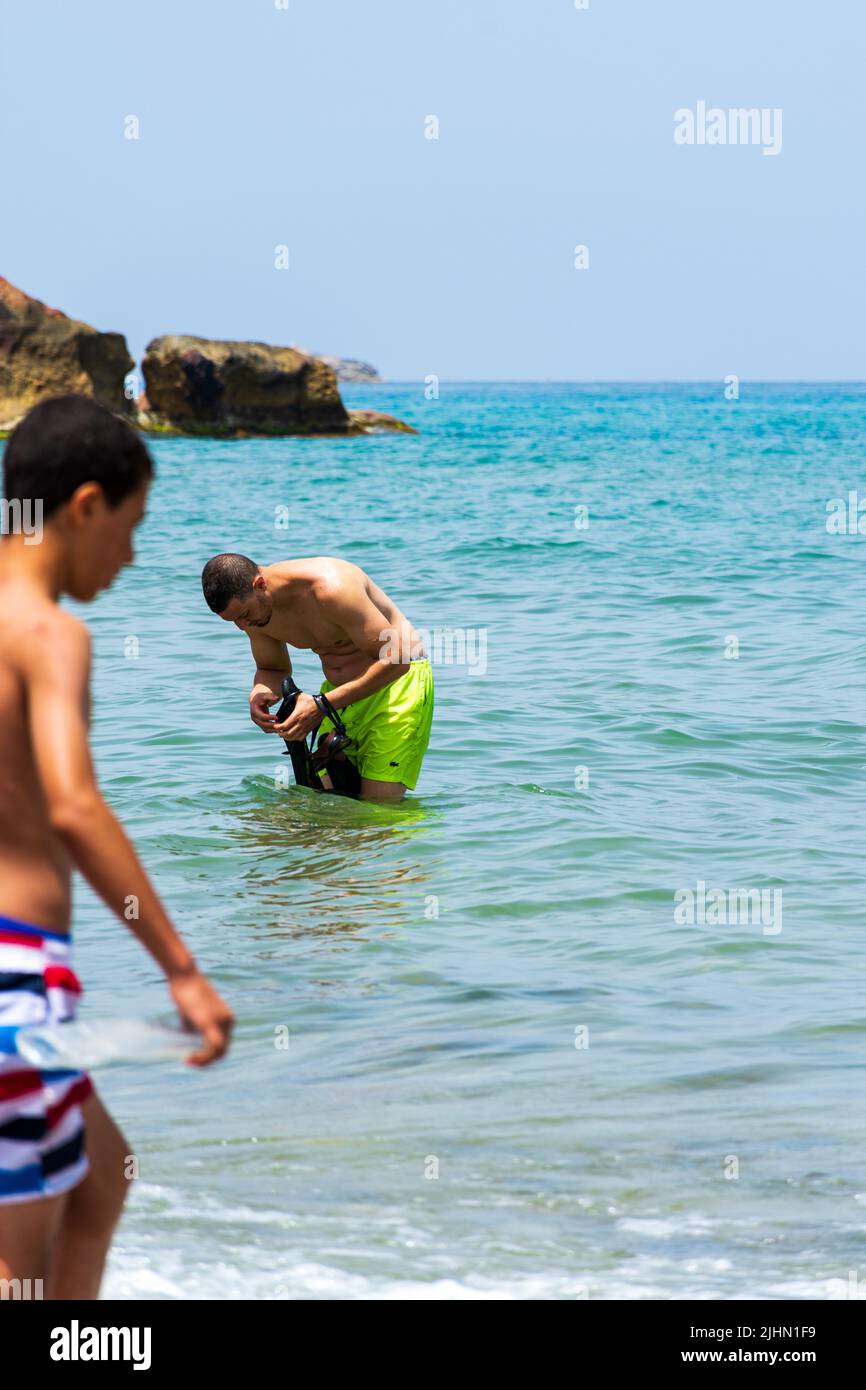 Junger arabischer Mann und Junge stehen in der Nähe des Strandes im Mittelmeer. Konzept für Sommerferien. Stockfoto