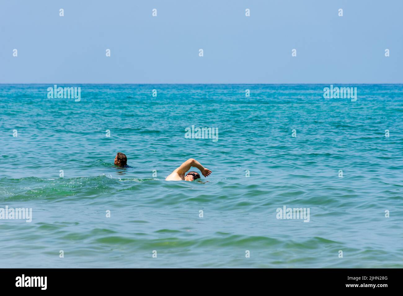 Blick auf einen jungen Mann, der im Mittelmeer schwimmend ist. Konzept für Sommerferien. Stockfoto