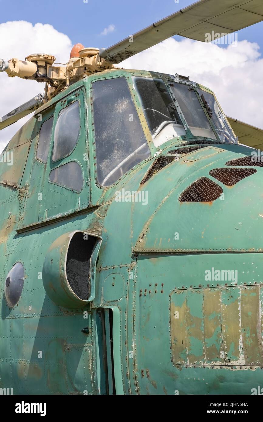 Seitenansicht des alten, verlassenen Militärhubschraubers. Gebrochener, nicht funktionstüchtiger sowjetischer Hubschrauber.vertikal. Stockfoto