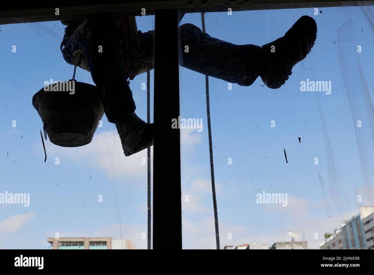 Abseilen Mann arbeiten an externen Fensterputzdienst und Gebäudereparatur. Arbeiter Abseilen Renovierung Gebäude. Zimmermann, Bauarbeiter Stockfoto