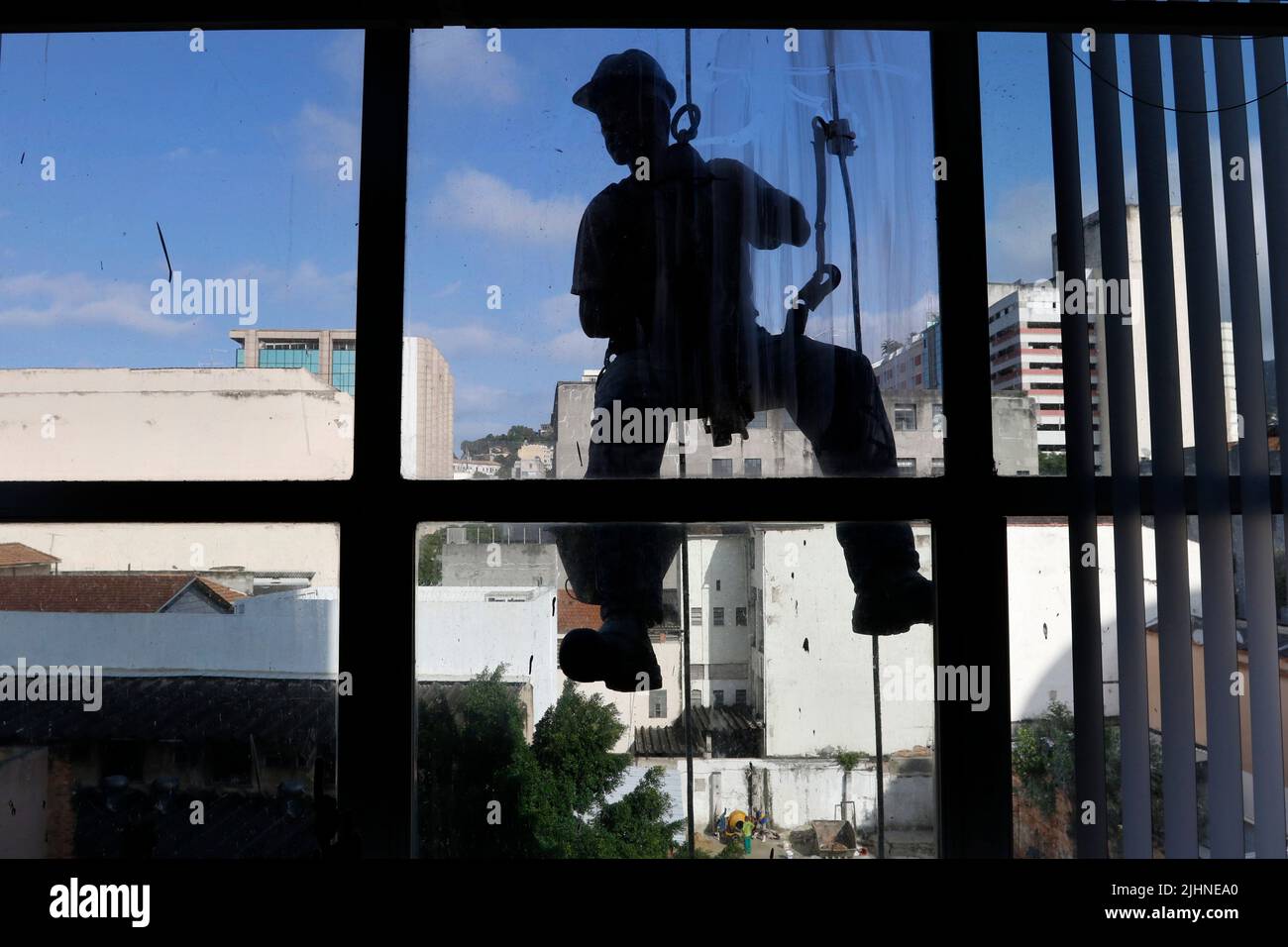 Abseilen Mann arbeiten an externen Fensterputzdienst und Gebäudereparatur. Arbeiter Abseilen Renovierung Gebäude. Zimmermann, Bauarbeiter Stockfoto