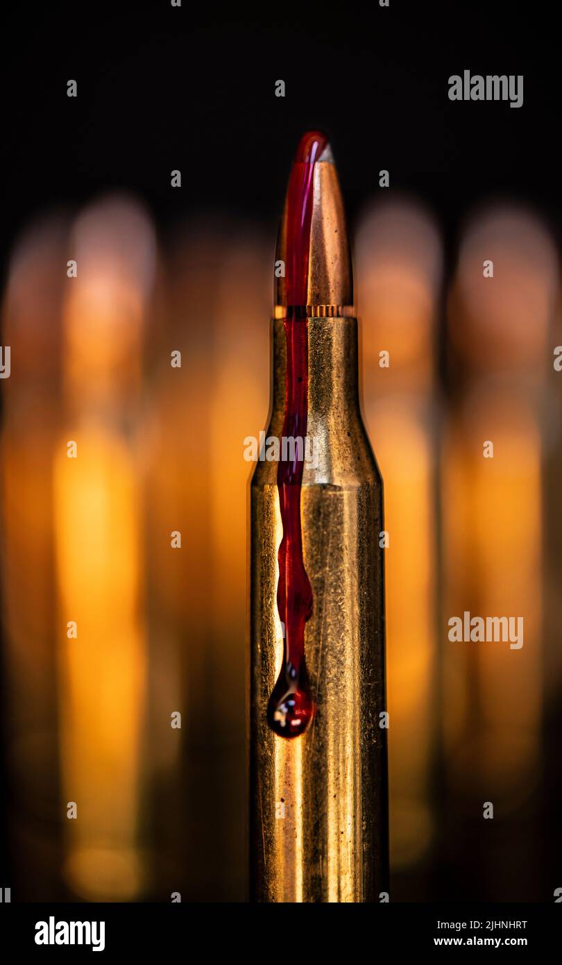 AR-15-Stil Gewehrpatrone und Blut (Fototafel). Stockfoto