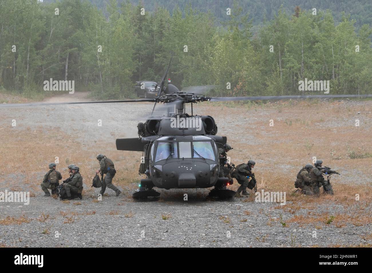 Mannschaftsoffiziere der Polizeibehörde von Anchorage, Special Weapons and Tactics (SWAT), verlassen eine Nationalgarde der Alaska Army UH-60L Black Hawk, die von einer Luftbesatzung betrieben wird, die dem Bataillon 1., 207. Aviation Truppenkommando auf der Joint Base Elmendorf-Richardson, Alaska, zugewiesen wurde, 13. Juli 2022. Die umfangreichen und strengen Trainingsbereiche von JBER boten den SWAT-Teams der lokalen Strafverfolgungsbehörden einen idealen Rahmen, da sie ihre Fähigkeiten im ländlichen Betrieb, die Aufgabenplanung, die Aufklärung, die Sicherheitsverfahren für Hubschrauber, die Landnavigation, Teambewegung und Patrouille. (USA Luftwaffe Foto von Alejandro Peña) Stockfoto