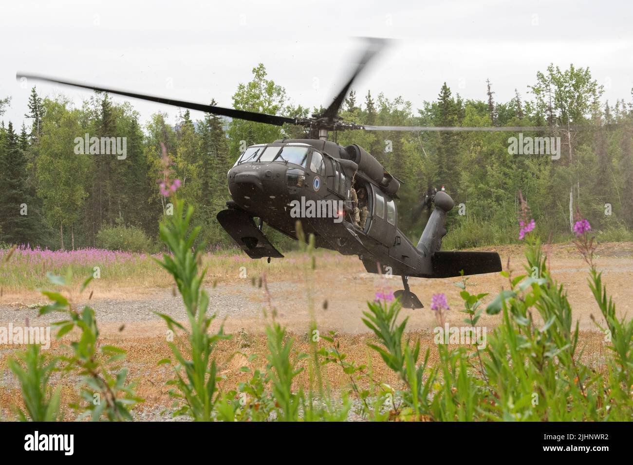 Eine Alaska Army National Guard UH-60L Black Hawk, die von einer Luftbesatzung betrieben wird, die dem Bataillon 1., dem 207. Aviation Truppenkommando, zugewiesen ist, transportiert Mitglieder des Anchorage Police Department und des Alaska State Troopers Special Weapons and Tactics (SWAT) Teams auf der Joint Base Elmendorf-Richardson, Alaska, 13. Juli 2022. Die umfangreichen und strengen Trainingsbereiche von JBER boten den SWAT-Teams der lokalen Strafverfolgungsbehörden einen idealen Rahmen, da sie ihre Fähigkeiten im ländlichen Betrieb, die Aufgabenplanung, die Aufklärung, die Sicherheitsverfahren für Hubschrauber, die Landnavigation, Teambewegung und Patrouille. (USA Luftwaffe Foto von Alejandro Peñ Stockfoto