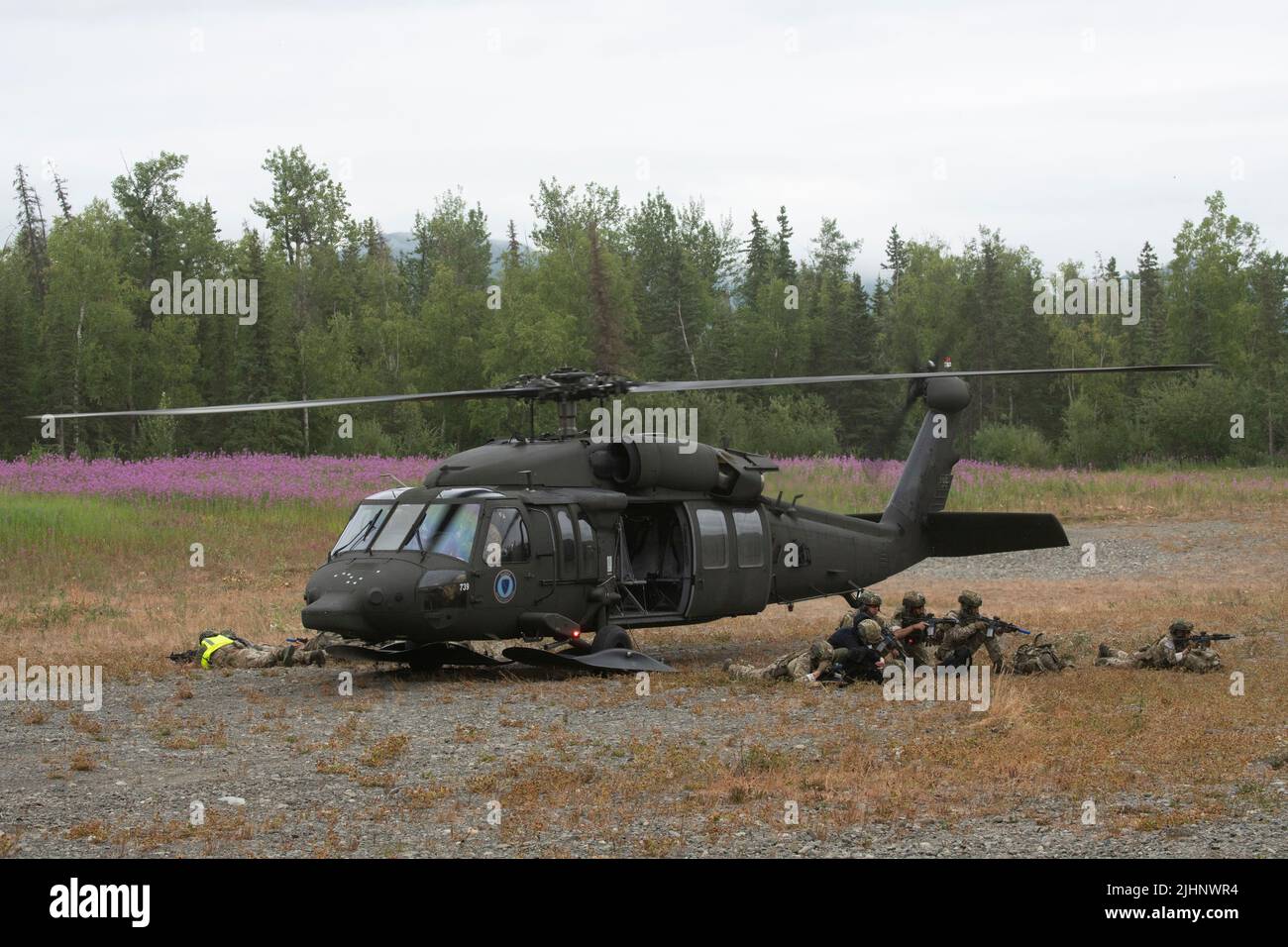 Spezialagenten des FBI Special Weapons and Tactics (SWAT)-Teams in Anchorage halten nach dem Verlassen einer Alaska Army National Guard UH-60L Black Hawk auf der Joint Base Elmendorf-Richardson, Alaska, 13. Juli 2022, Sicherheit. Die umfangreichen und strengen Trainingsbereiche von JBER boten den SWAT-Teams der lokalen Strafverfolgungsbehörden einen idealen Rahmen, da sie ihre Fähigkeiten im ländlichen Betrieb, die Aufgabenplanung, die Aufklärung, die Sicherheitsverfahren für Hubschrauber, die Landnavigation, Teambewegung und Patrouille. (USA Luftwaffe Foto von Alejandro Peña) Stockfoto