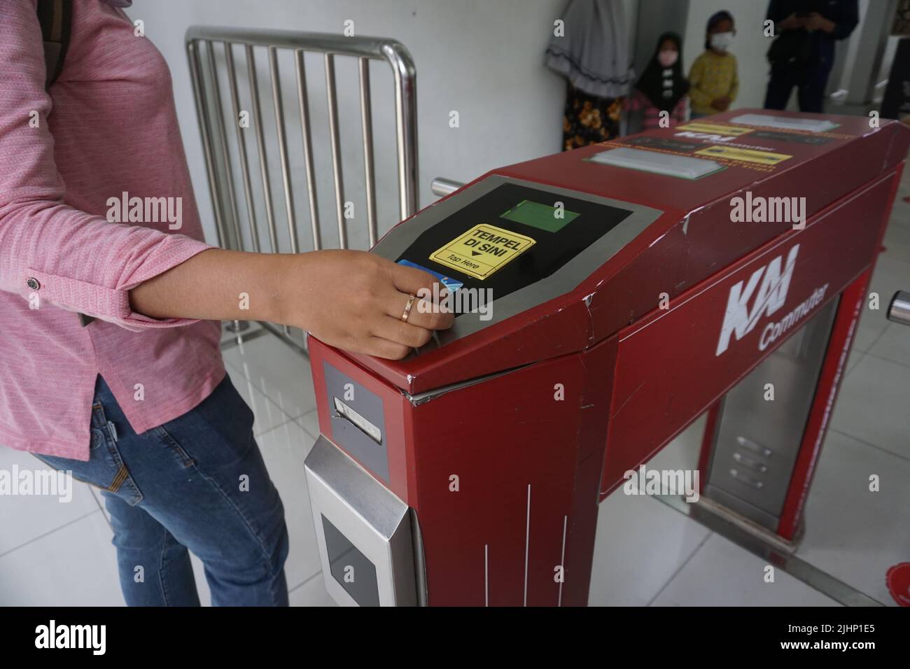 Solo, Indonesien - 16.. Juli 2022. Eine Frau strichen eine E-Money-Karte, um ein Ticket für die KRL-Pendlerlinie zu bezahlen, bevor sie den Bahnhof Solo Balapan betreten. Stockfoto
